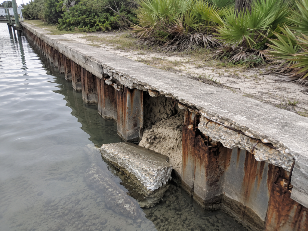 Crumbling seawall along a coastal inlet